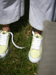 Top view of pastel green sneakers with gold embellishment and breathable lining