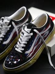 Custom Vans Old Skool sneakers hand-painted with a distressed American flag design, white laces and vintage yellow soles by STUCC NYC.
